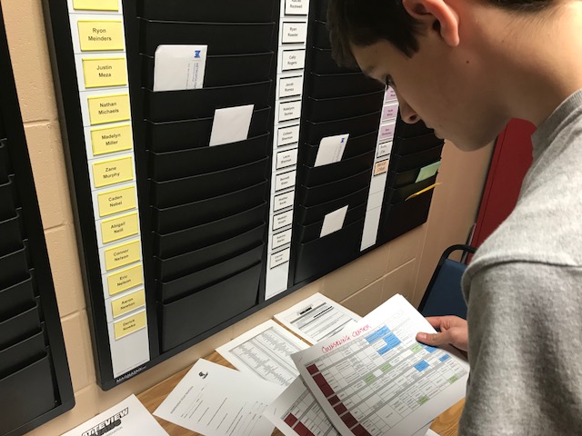 John Kinney checks uses materials by Mr. Stantons office to plan out his classes for next semester.