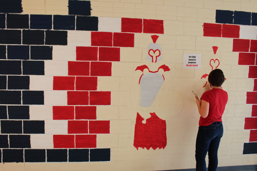 Junior Pruett Newton paints the activities mural in the vending machine hallway.