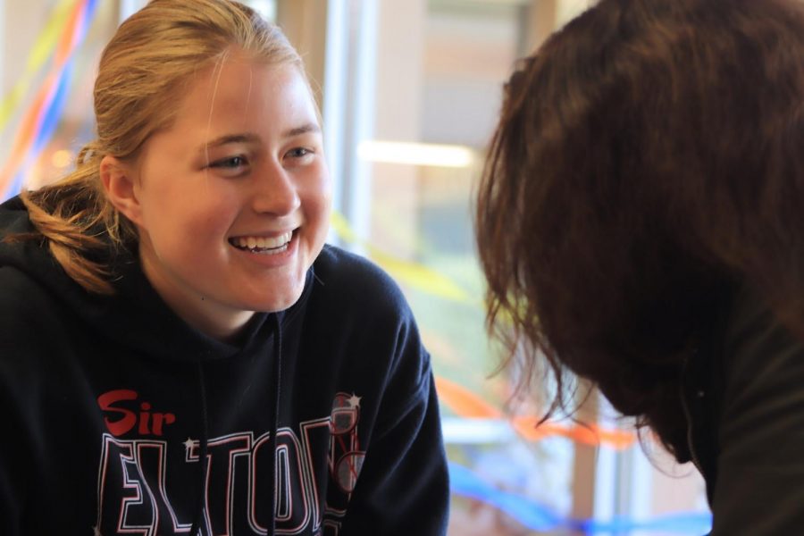Senior Elise Lutz laughs with a friend in the student lounge.