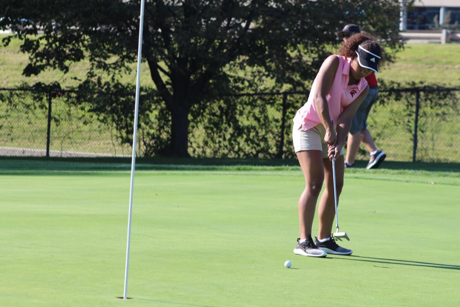 Desiree McDowell is on the green hitting with her putter at the girls golf match against Brownell-Talbot.