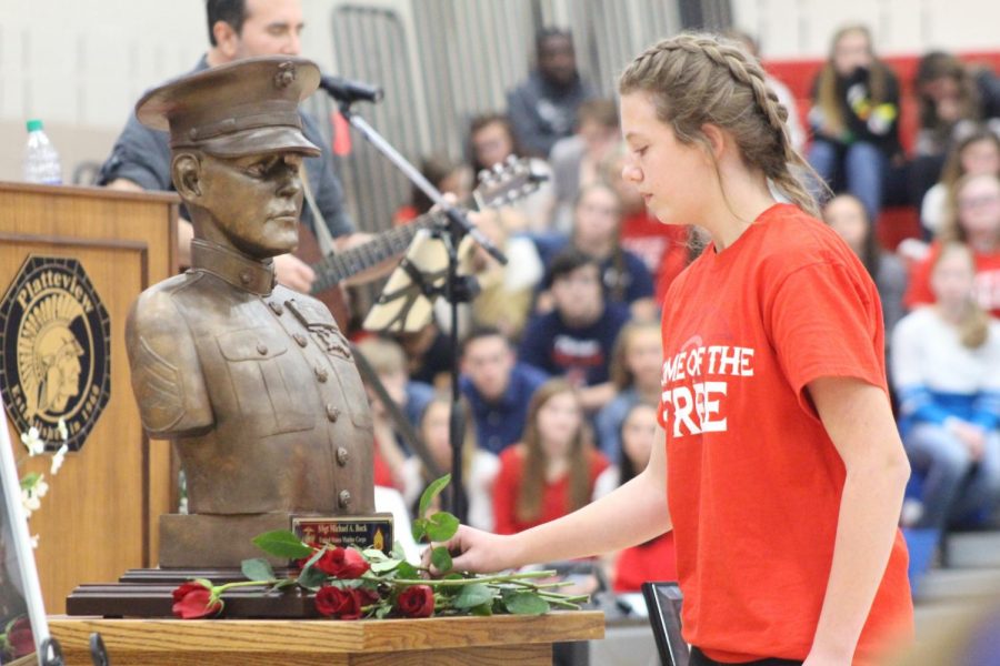 Seventh grader Cassie Coenen places a rose near the bust of fallen Marine Staff Sergeant Michael A. Bock during the Veteran’s Day Program held at Platteview High School on November 11, 2019. The memorial will be housed in Platteview Central’s Media Center.