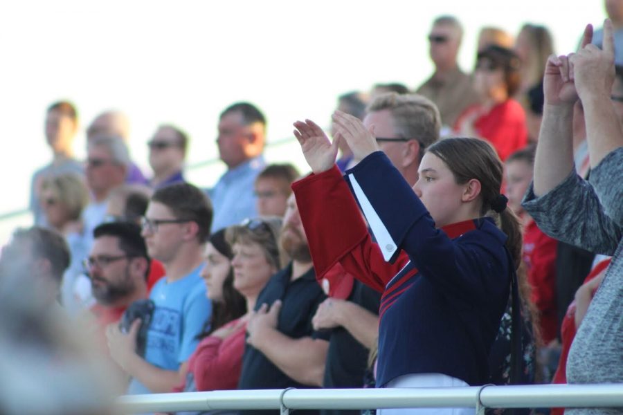 Drum Major Claire Snodgrass (11) co-directs the band to “Star Spangled Banner” at 
a Platteview home football game.