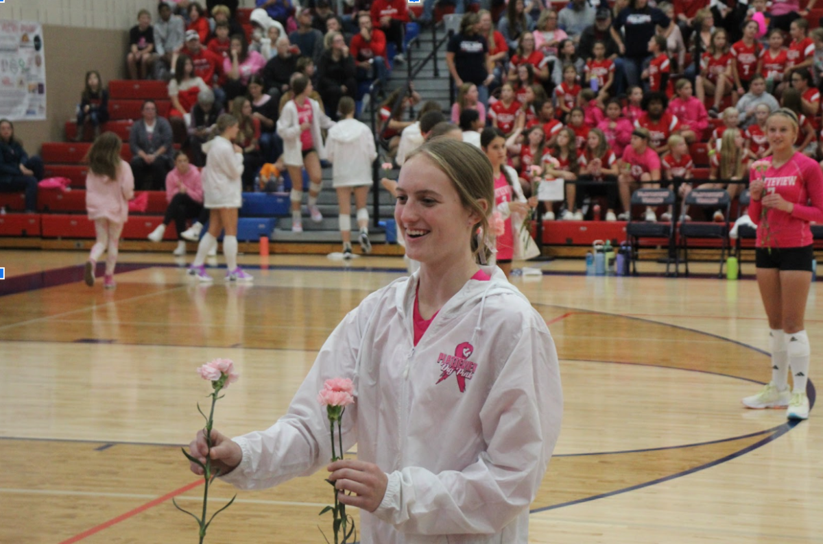 Flowers Support:
Brooklyn Stehlik (10) handing out flowers to the families and women with breast cancer, to show the volleyball team’s support. 

